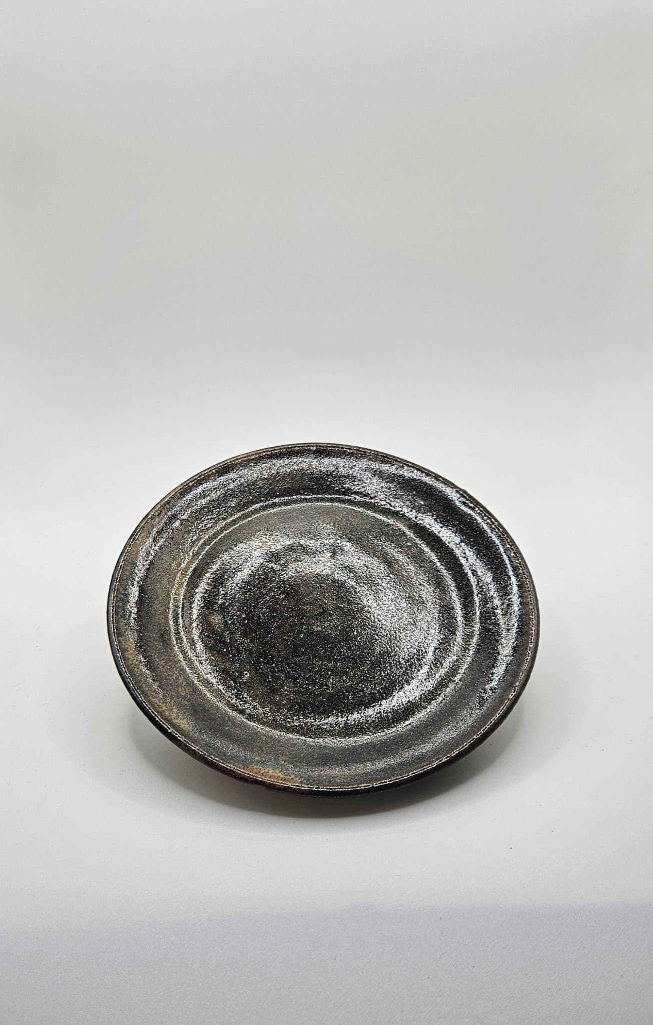 Dark glazed stoneware plate photographed from above