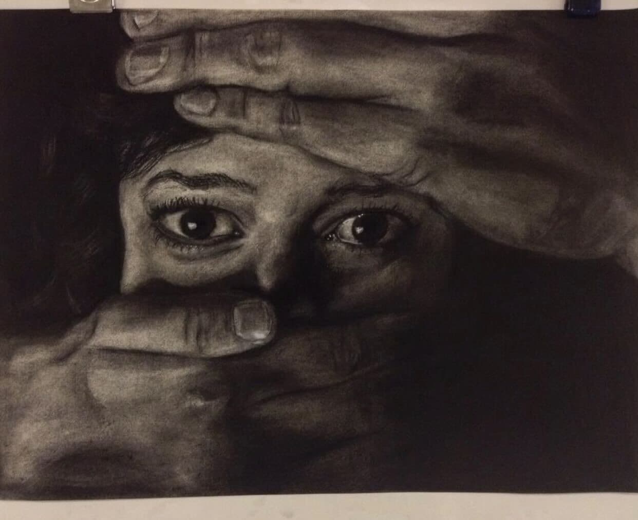 Monochrome drawing of a face framed by hands